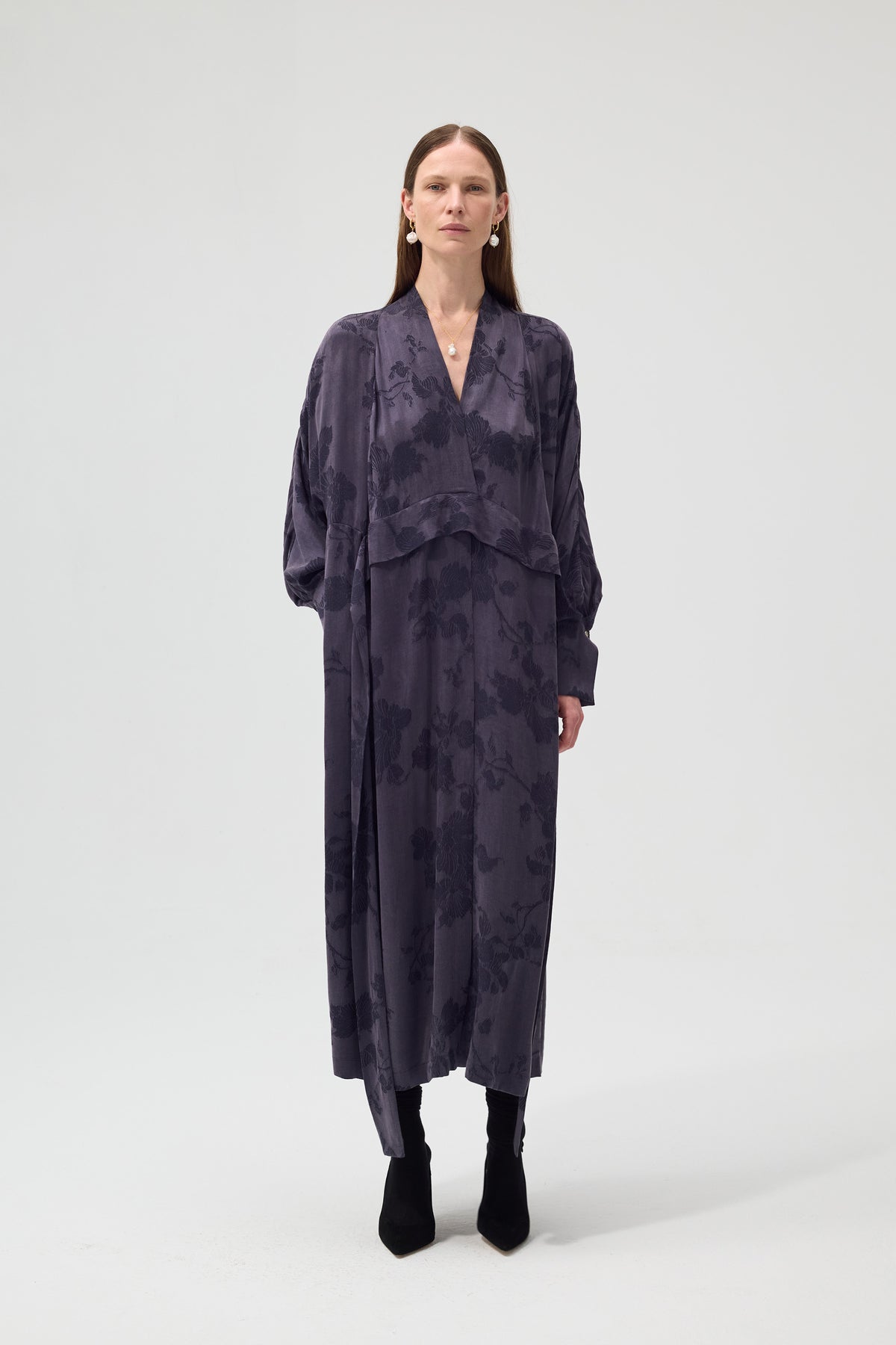 Woman wearing a dark floral dress on a white background